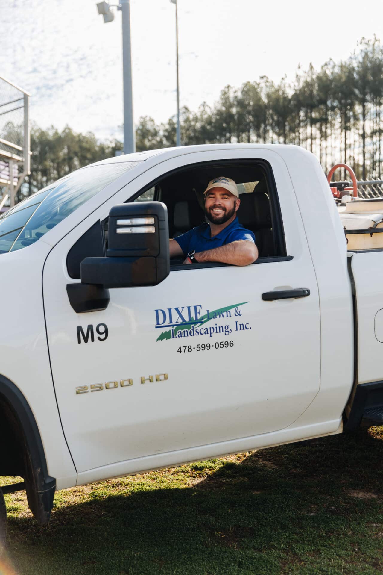 man sitting in work truck smiling at the camera