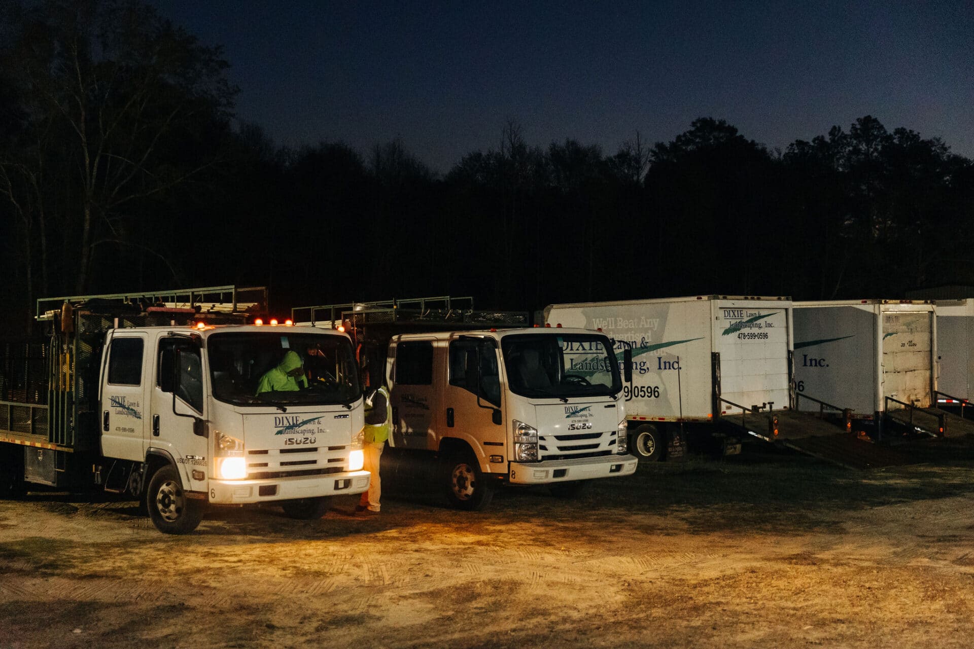 nighttime image of field with work trucks ready to drive off